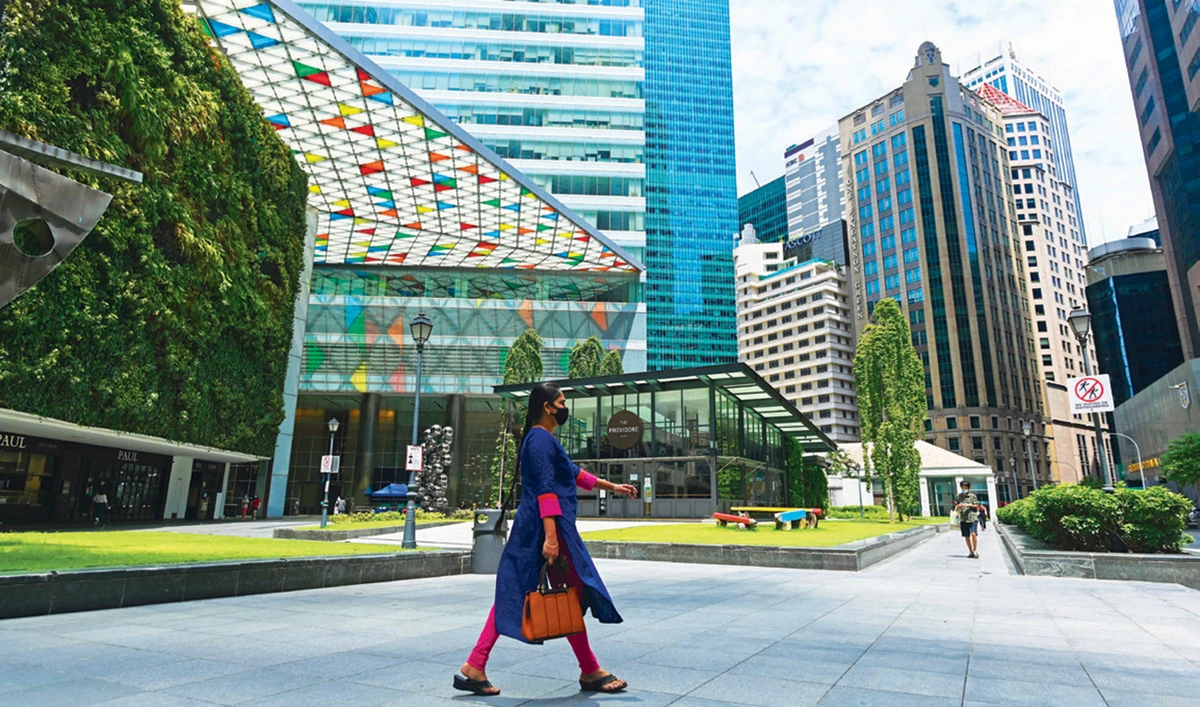A woman wearing a facemask as preventive measure against the spread of the coronavirus (COVID-19) walks at the business district in Singapore. (AFP)