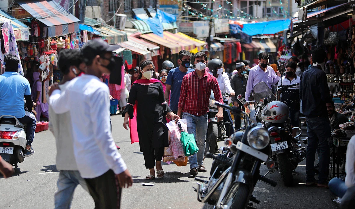 Indians wearing masks as a precaution against the coronavirus disease (COVID-19) enjoy a day out at a market in Jammu on Sunday. (AP)
