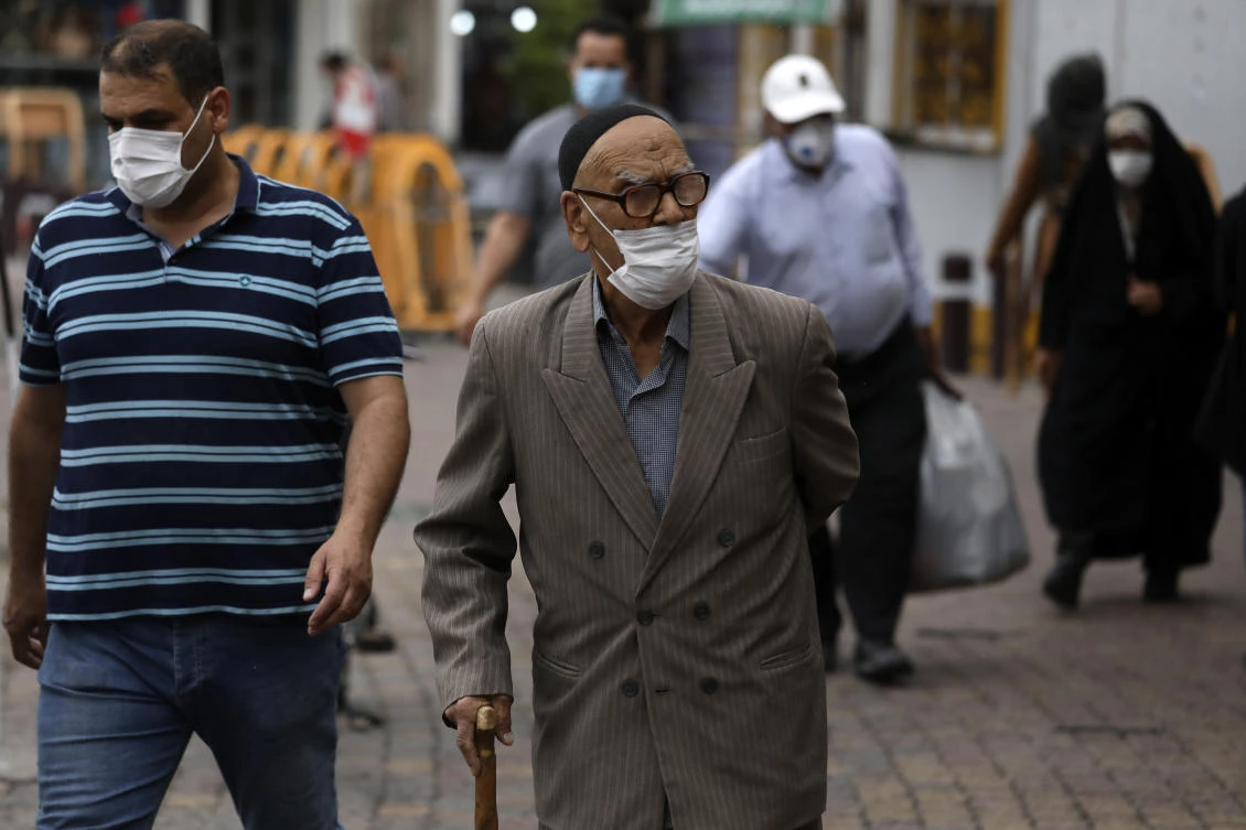 People wearing protective face masks to help prevent the spread of the coronavirus walk on a sidewalk in the city of Zanjan, some 330 kilometers (205 miles) west of the capital Tehran, Iran, Sunday, July 5, 2020. (AP)