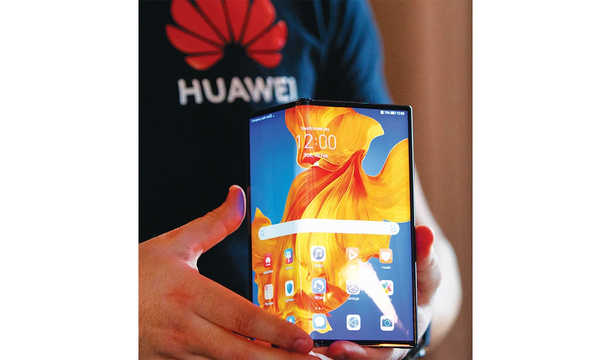 An employee displays the Huawei Mate Xs to the media during a photocall for the launch of the new foldable smartphone in London. (AFP/File)