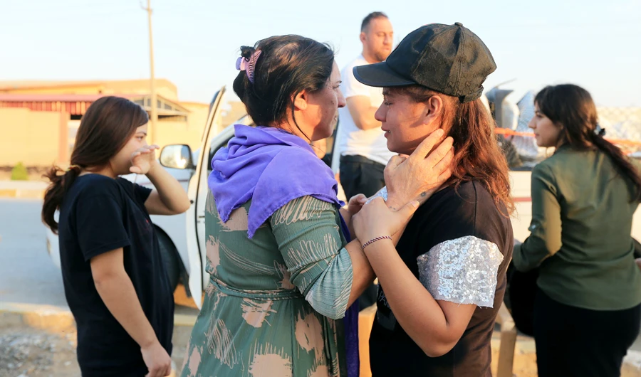 Gole Zeblo Ismaeel, daughter in-law of Nayef al-Hamo, a Yazidi displaced man, hugs her neigbour before heading back to Sinjar following the outbreak of the coronavirus disease (COVID-19) and economic crisis, near Dohuk, Iraq July 4, 2020. (REUTERS)