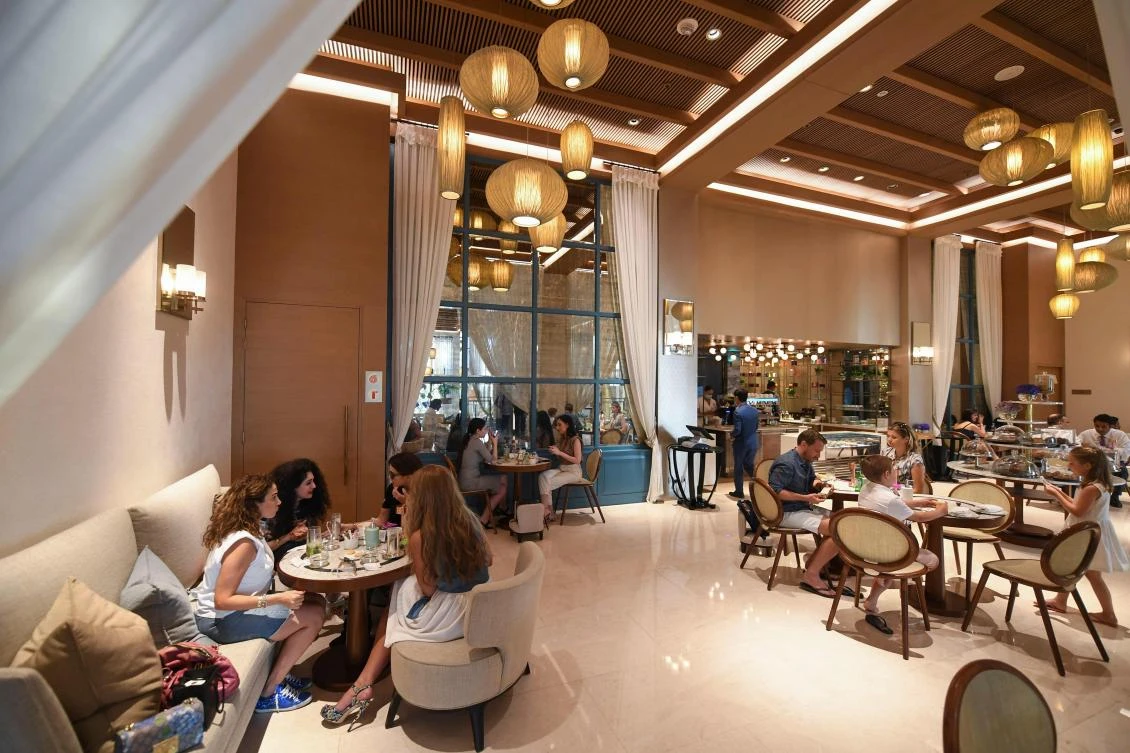 Tourists sit at a restaurant at the Al Naseem hotel in Dubai in the United Arab Emirates, on July 7, 2020. (AFP)