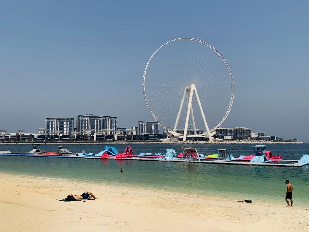 A man sunbathes along the Marina beach near the Ain Dubai Ferris wheel in the Gulf emirate of Dubai on July 7, 2020. (AFP)