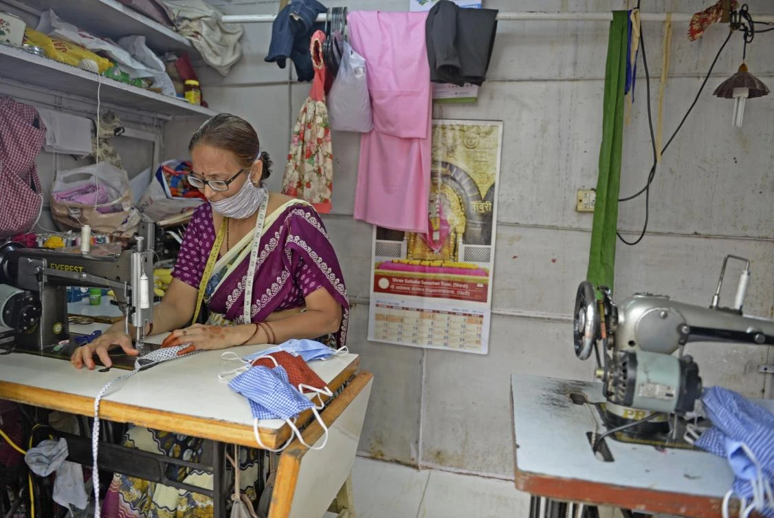 Talla Vijaya Lakshmi, a tailor stitches face masks in her temporary shop on the roadside in Hyderabad on July 9, 2020. (AFP)