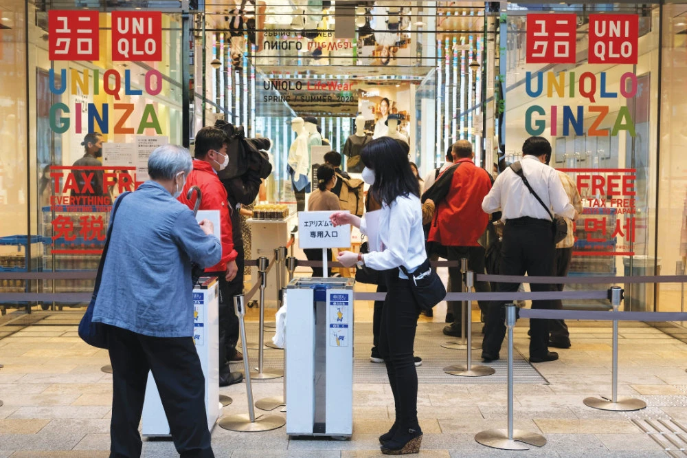 Customers wait in a queue outside a Uniqlo store in Tokyo’s Ginza shopping district. Same-store sales are up 26 percent from June 2019. (AFP)