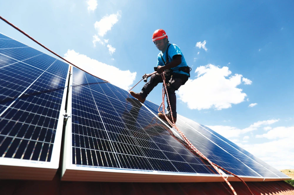 A worker sets up solar panels on the roof of a home in Colmenar Viejo, Spain. Some Spanish renewable energy firms are offering to install panels for free. (Reuters)