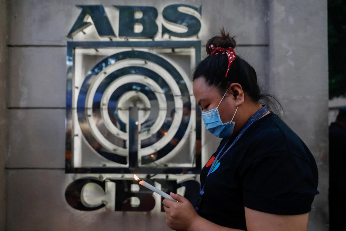 An ABS-CBN employee holds a candle during a prayer gathering as Philippine lawmakers hear the broadcast network’s franchise renewal on July 9, 2020. (Reuters)