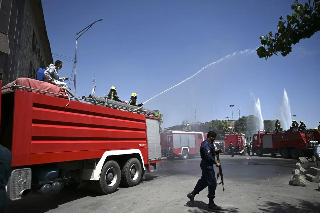 Firefighters spray disinfectant on a street as a preventive measure against the spread of coronavirus in Kabul on June 18, 2020. (AFP file photo)