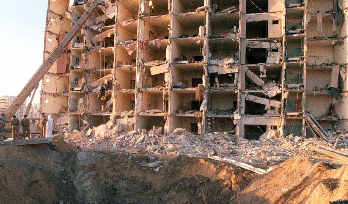 In this file photo taken on 27 June, military personnel survey the damage to Khobar Towers caused by the 25 June explosion of a fuel truck outside the northern fence of the facility on King Abdul Aziz Air Base near Dhahran, Saudi Arabia. (AFP)