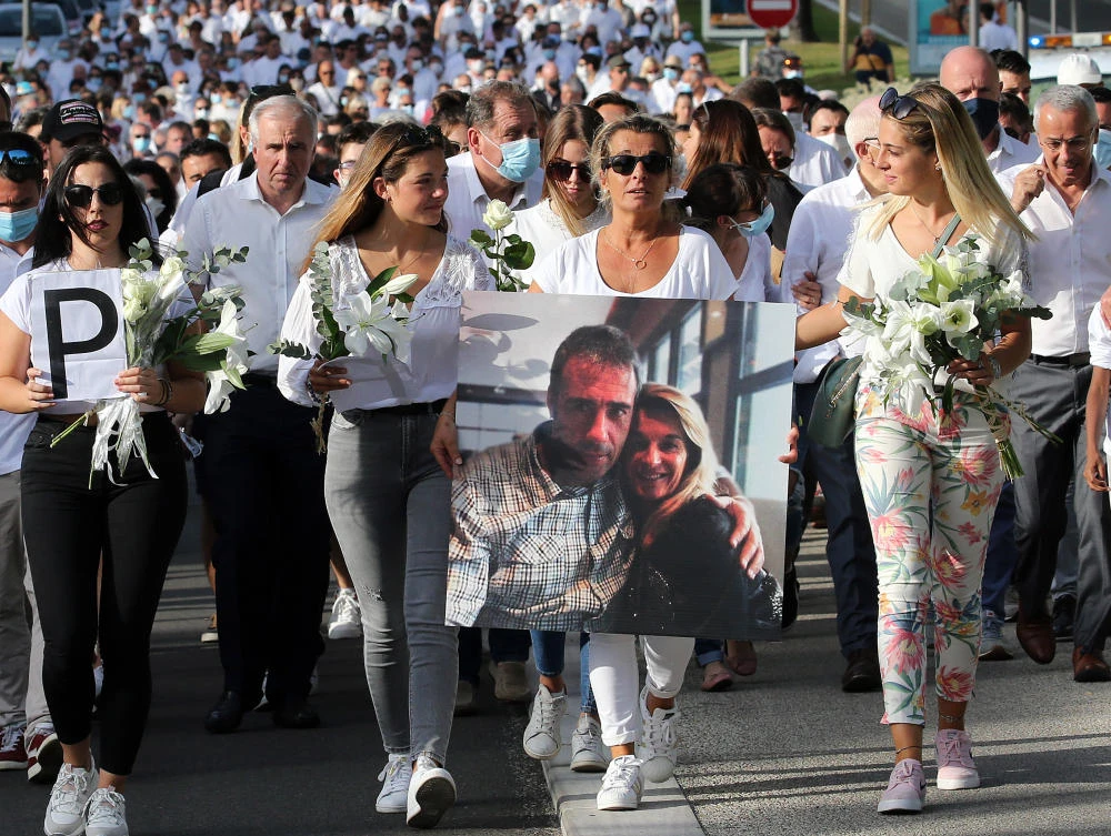 Veronique Monguillot, wife of Philippe Monguillot, a bus driver who was attacked in Bayonne on Sunday night, holds a photo of her with her husband, during a protest march in Bayonne, southwestern France, Wednesday, July 8, 2020. (AP)