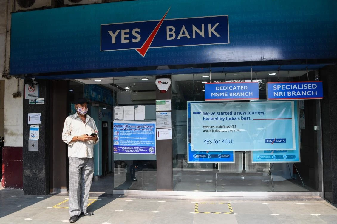 A man walks past a Yes Bank branch in New Delhi on July 9, 2020. India's embattled Yes Bank, which was on the brink of collapse earlier this year, announced plans on July 9 to raise up to 150 billion rupees ($2 billion) in a Mumbai stock listing. (AFP)