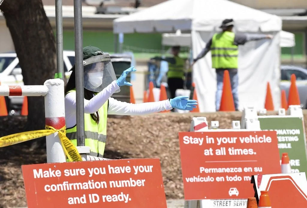 Volunteers assist residents arriving at a mobile coronavirus test site in Los Angeles, California on July 10, 2020. (AFP)