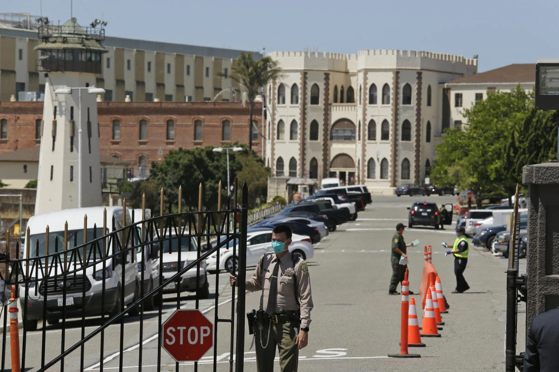 This July 9, 2020, file photo shows a correctional officer closing the main gate at San Quentin State Prison in San Quentin, Calif. California is giving more than 100,000 state inmates earlier release dates in its latest response to the pandemic, building on earlier steps that together could free nearly 10% of prisoners as Gov. Gavin Newsom responds to intensifying pressure from advocates, lawmakers and federal judges. (AP)
