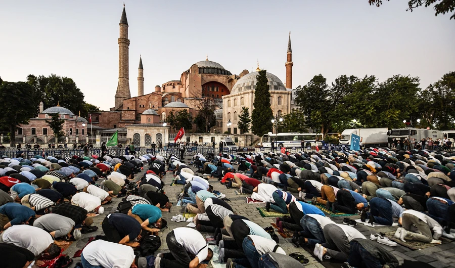 People, some wearing face masks, pray outside the Hagia Sophia museum in Istanbul on July 10, 2020 as they gather to celebrate after a top Turkish court revoked the sixth-century Hagia Sophia's status as a museum, clearing the way for it to be turned back into a mosque. (AFP)