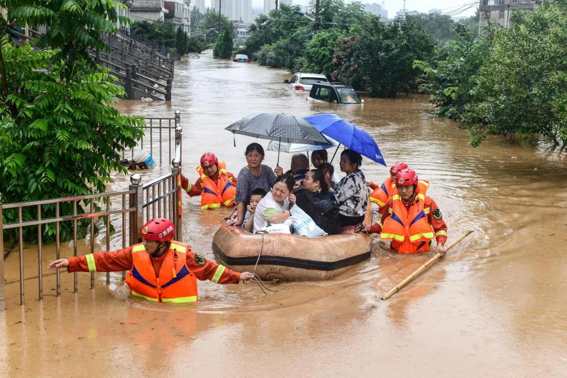 Rescuers evacuate flood-affected residents following heavy rain in Jiujiang in China's central Jiangxi province on July 8, 2020. (AFP)