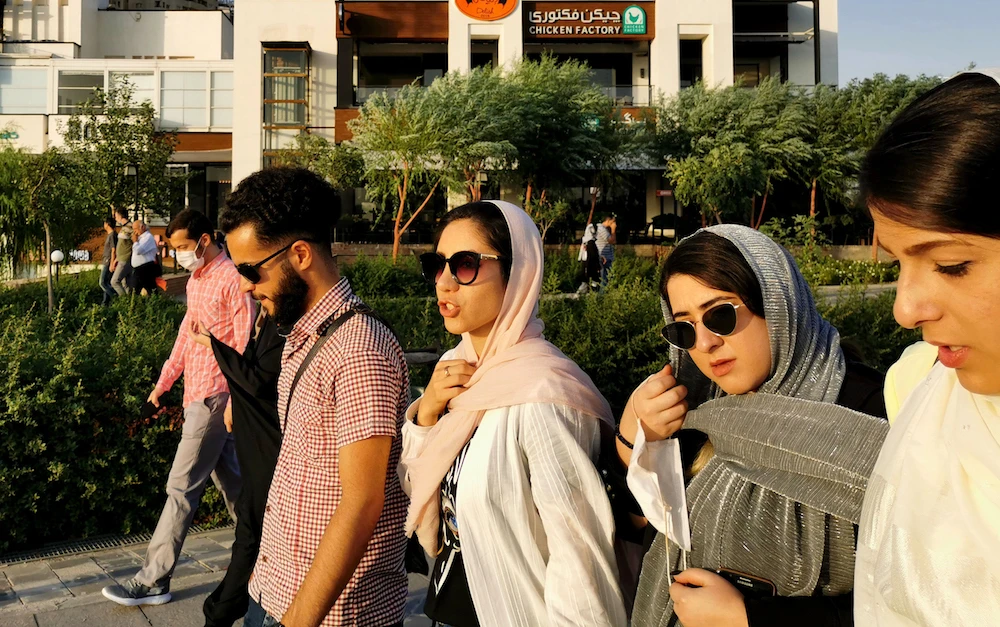Iranians walk along a street near the artificial Chitgar lake in the capital Tehran, amid the novel coronavirus pandemic crisis on July 3, 2020. (AFP)