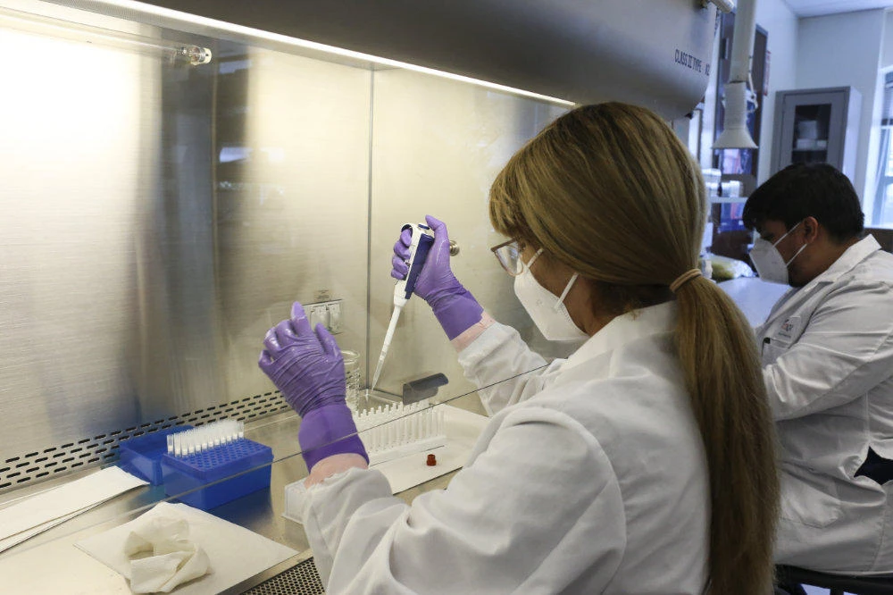 Lab technician Thalia Rios withdraws a small amount of liquid from a COVID-19 swab sample for testing onJuly 10, 2020, at the UT Health RGV Clinical Lab on the UTRGV campus in Edinburg, Texas. (Denise Cathey/The Brownsville Herald via AP)