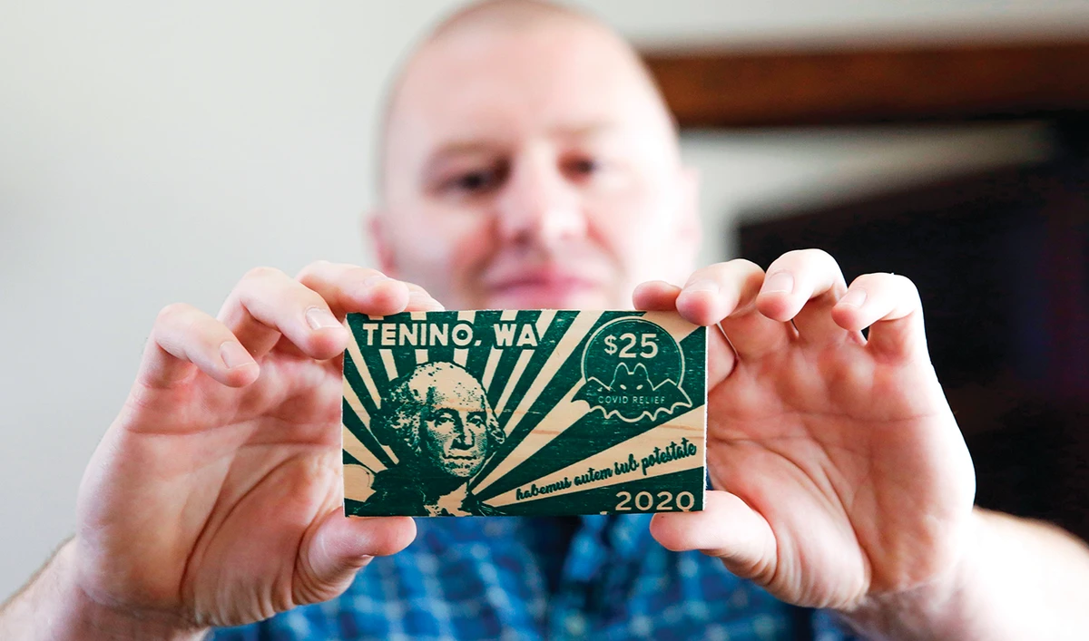 Mayor Wayne Fournier holds $25 in wooden money, in Tenino, Washington. (AFP)
