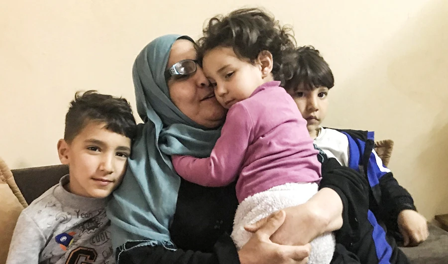 Taheyya, a grandmother from the Tunisian city of Kairouan, about 160 kilometres south of the capital Tunis, is pictured with her grandchildren whose uncle was killed in Syria, at her home on March 9, 2020. (AFP)
