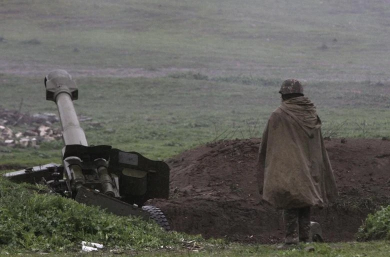 An Armenian soldier of the self-defense army of Nagorno-Karabakh stands near an artillery unit in the town of Martakert. (Reuters)