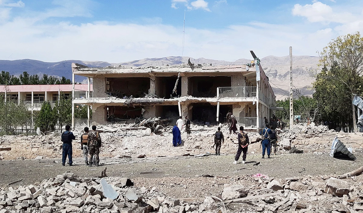 Afghan security personnel inspect the site of a car bomb blast near the destroyed office building of Afghanistan’s intelligence agency in the city of Aybak on Monday. (AFP)