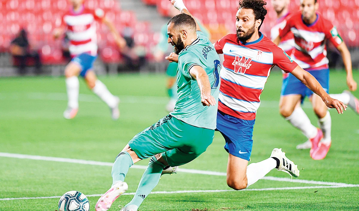 Real Madrid’s French forward Karim Benzema, left, up against Granada’s Spanish defender German Sanchez during their Spanish league football match on Monday. (AFP)