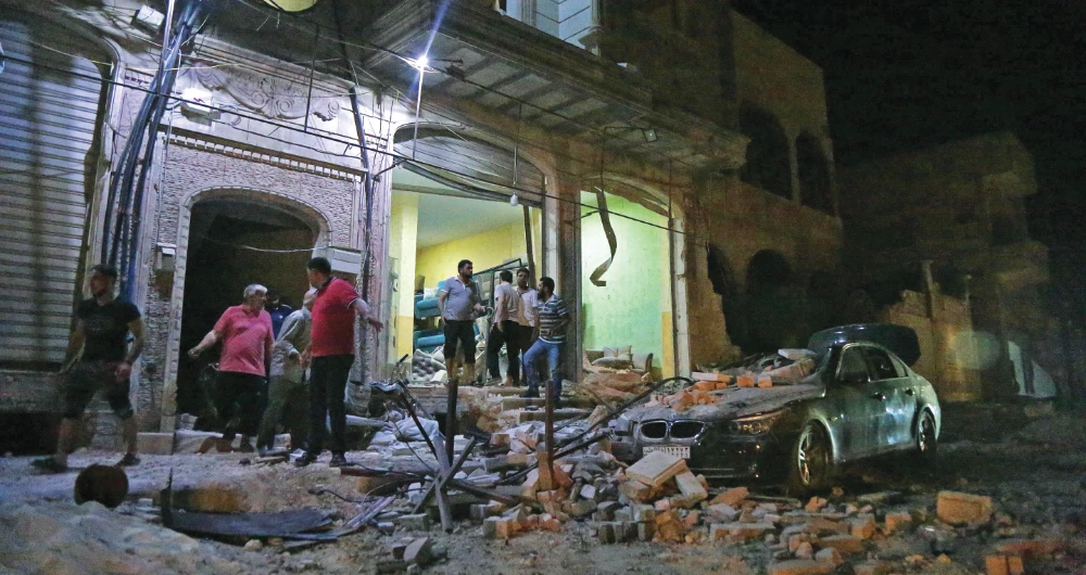Syrians gather at the scene of an airstrike in the city of Al-Bab in a rebel-held area in the north of Aleppo province late on Wednesday. (AFP)