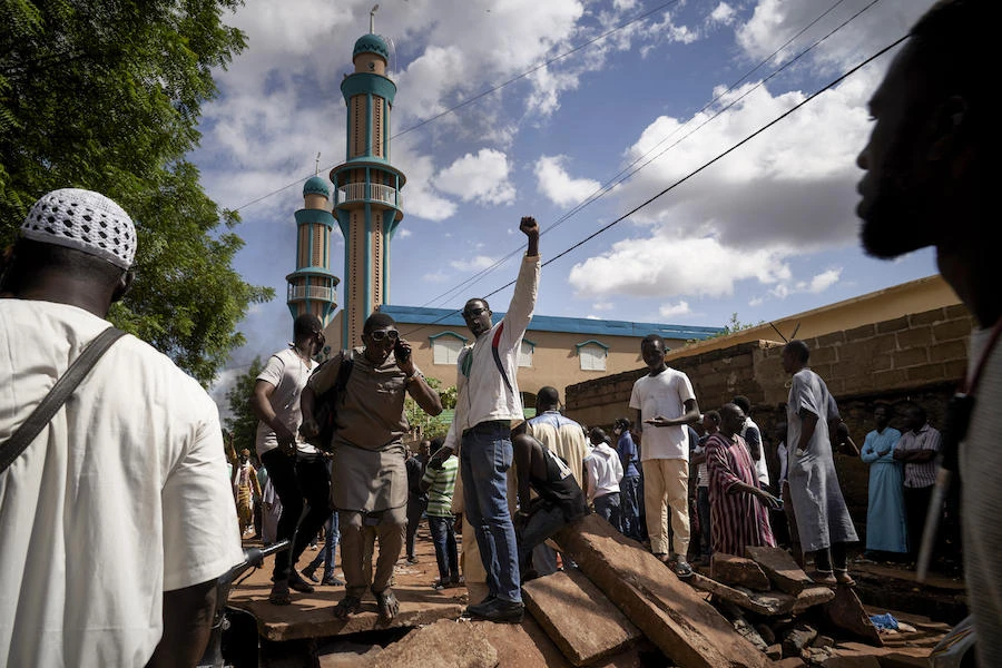 Protesters gestures on a barricade put up in front of the Salam mosque of Badalabougou, where the influent Imam Mahmoud Dicko led a prayer dedicated to the victims of the clashes of the past two days in Bamako on July 12, 2020. (AFP)