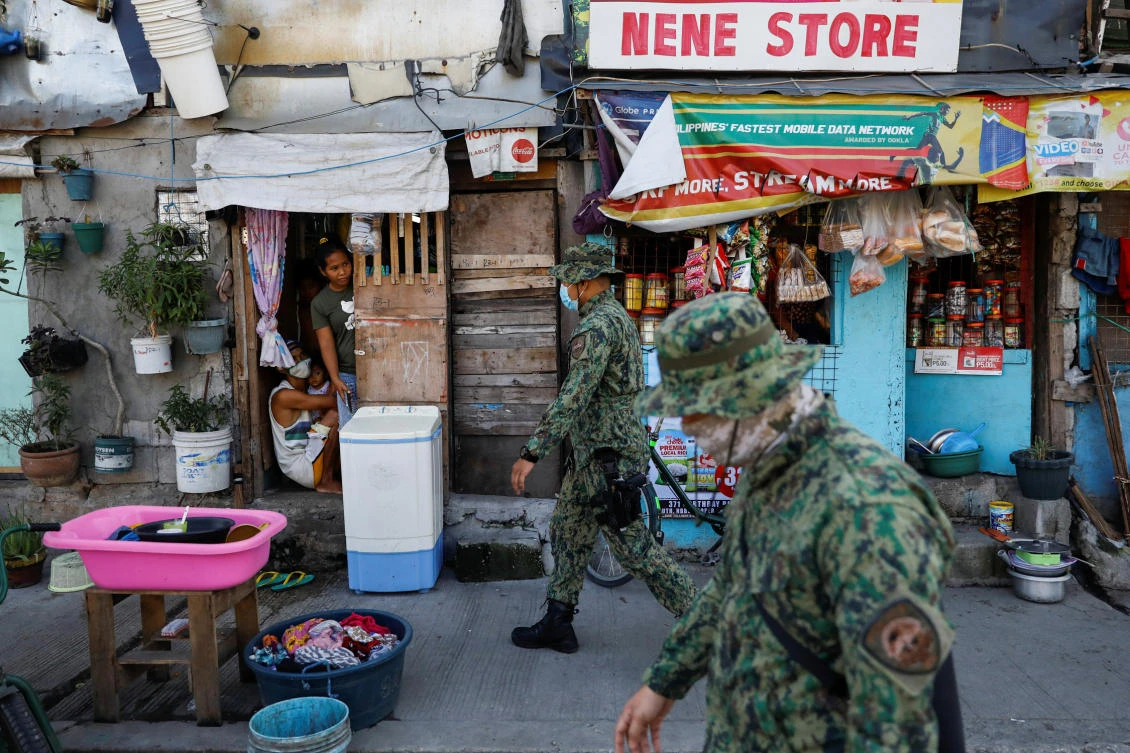 Police officers patrol a neighborhood to enforce the reimposed lockdown due to a spike in the coronavirus cases in Navotas of Metro Manila. (Reuters)