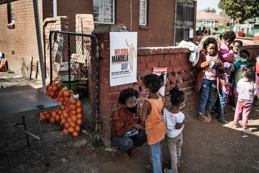 Children gather while waiting the beginning of the special Mandela day lunch served by the volunteers for the grassroots charity Hunger has no Religion in Johannesburg on July 18, 2020. (AFP / MARCO LONGARI)