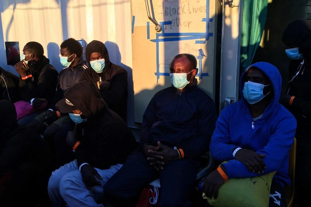 Migrants wearing protective facemasks on board of the humanitarian aid boat Ocean Viking, chartered by charity group SOS Mediterranee. (File/AFP)