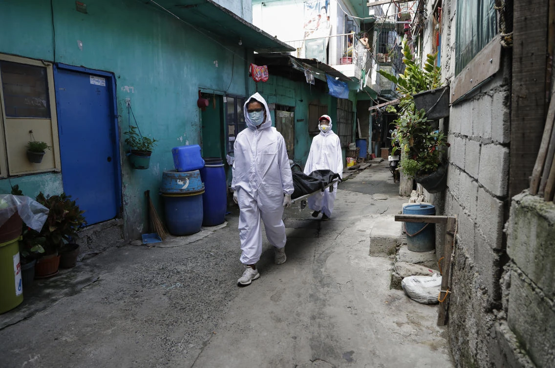 Funeral home workers in protective suits carry a body during the start of a lockdown due to a rise in COVID cases in the city of Navotas, Manila, Philippines on Thursday, July 16, 2020. Coronavirus infections continue to rise in the country after reopening the economy that is on the brink of a recession while still struggling to combat the pandemic. The cause of death is unconfirmed. (AP)