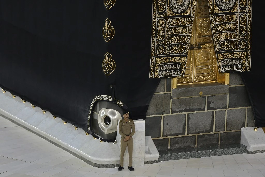 A Saudi security officer stands guard next to the Kaaba in Mecca's Grand Mosque, Islam's holiest site on April 27, 2020. (AFP)