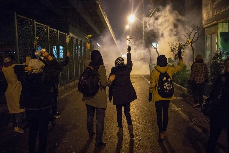 Iranian protesters hold flowers as riot police fire tear gas during a demonstration in front of Tehran’s Amir Kabir University on January 11, 2020. (File/AFP)
