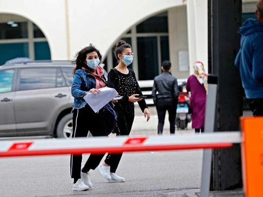 Young women wearing protective masks walk out of the Rafik Hariri University Hospital in the southern outskirts of the Lebanese capital Beirut on February 21, 2020. (AFP)