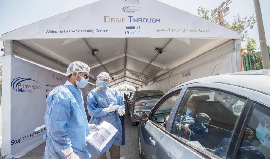 Egyptian health workers collect samples at a drive-through coronavirus-testing center at the Ain Shams University in Cairo on June 29, 2020. (AFP)