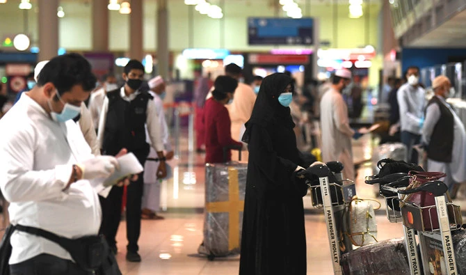 Pakistani nationals check in at the Dubai International Airport before leaving the Gulf Emirate on a flight back to their country, on May 7, 2020, amid the novel coronavirus pandemic crisis. (AFP)