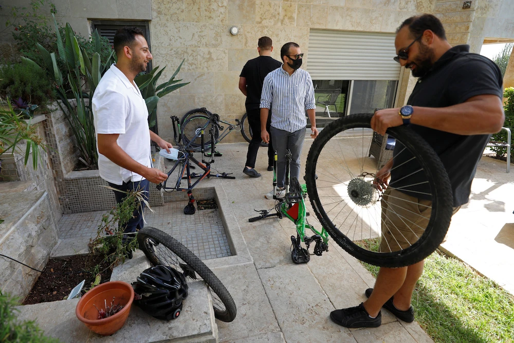 Palestinian cyclists Amer Kurdi and Jerees Rayan inspect their damaged bicycles in Ramallah in the Israeli-occupied West Bank July 21, 2020. (Reuters)