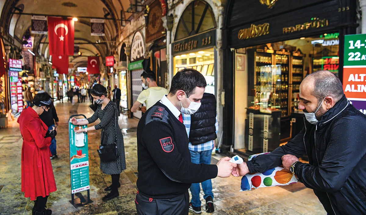 The reopening of the Grand Bazaar in Istanbul signified an easing of the national lockdown, but President Erdogan, inset, has not been able to prevent the currency sliding. (AFP)