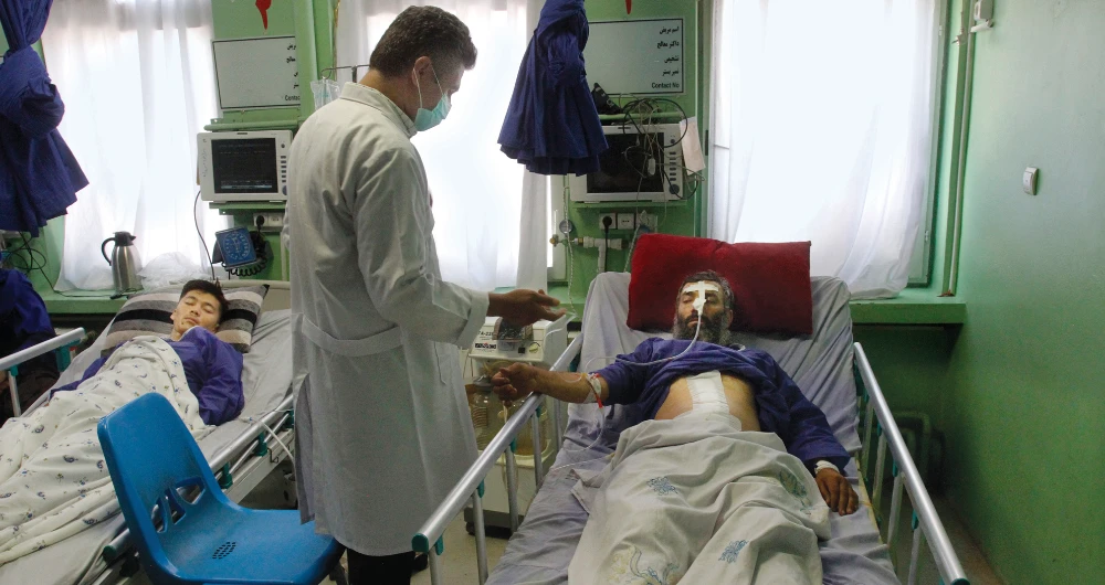 An injured man, right, is treated at a hospital after an airstrike in Adraskan district of Herat province, west of Kabul on Thursday. (AP)
