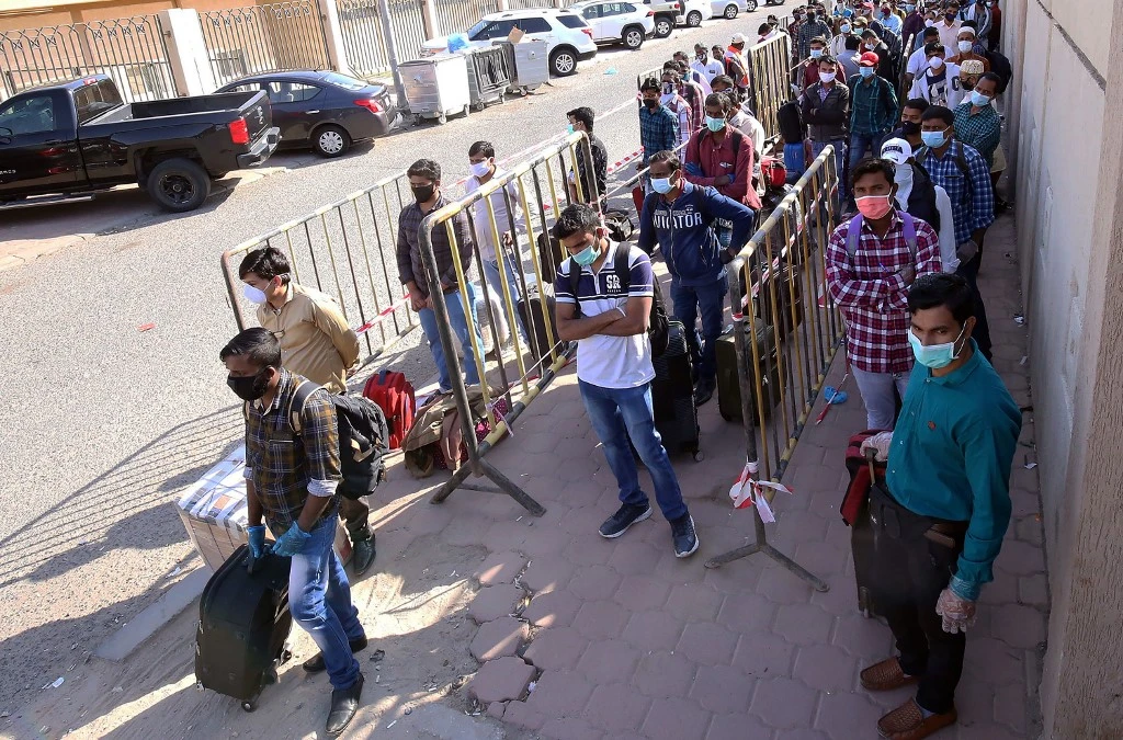 Indian nationals queue outside a school to receive residency violators wishing to avail an amnesty Kuwait on April 16, 2020. (AFP)