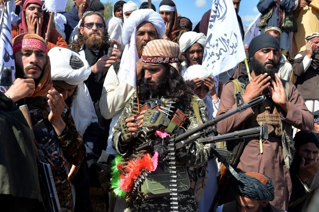 Afghan Taliban militants and villagers attend a gathering as they celebrate the peace deal on March 02, 2020. (AFP)