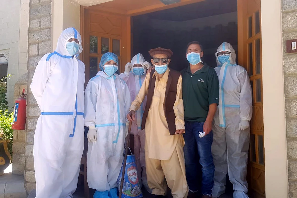 Abdul Alim, 103, stands with his son and staff members in this group photograph taken after he recovered from COVID-19 and was discharged from the center. (Reuters)