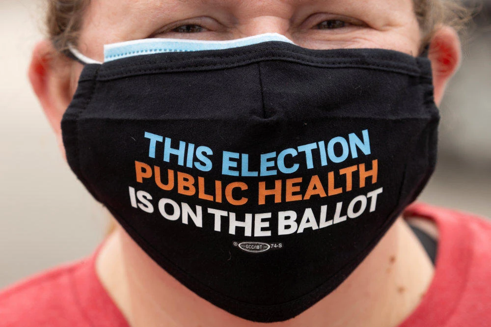 A teacher joins in with healthcare workers during a protest for Personal Protective gear at a hospital in Westminster, California, on July 22, 2020 amid the raging coronavirus pandemic. Citizens are also enjoined to wear masks whenever they venture outside their homes to help fight the coronavirus. (REUTERS/Mike Blake)