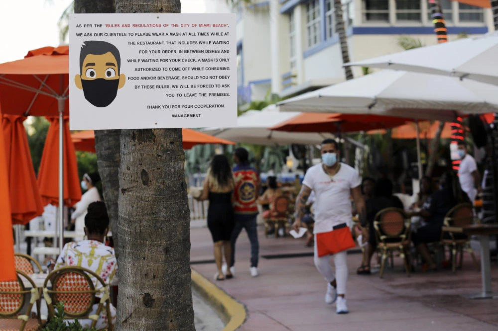A sign informs customers at the Edison Hotel restaurant about wearing a protective face mask during the coronavirus pandemic on July 24, 2020, along Ocean Drive in Miami Beach, Florida. (AP Photo/Lynne Sladky)