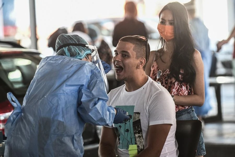 A public health worker collects a swab sample from a man to test for the COVID-19, the novel coronavirus, at the Greek-Bulgarian border crossing in Promachonas on July 10, 2020. (File/AFP)
