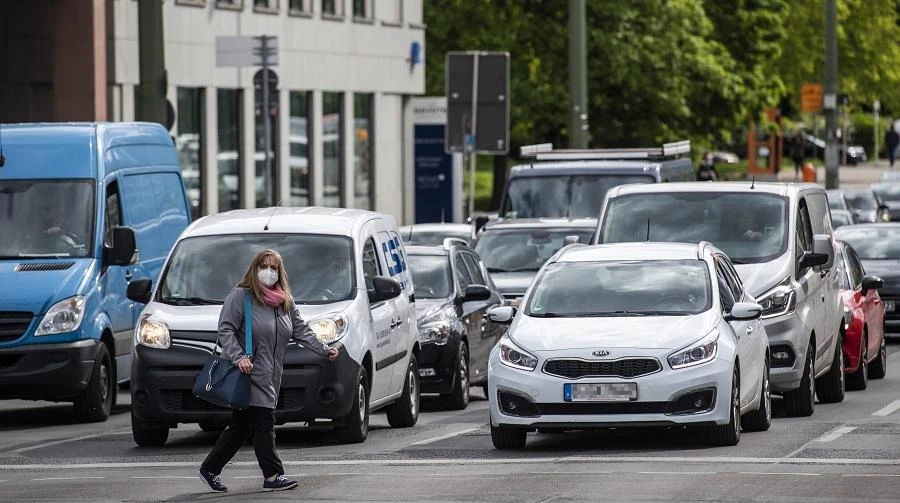 A woman wearing a face mask crosses in front of traffic in central Berlin on May 14, 2020, as a relaxation of lockdown restrictions in the capital has led to more cars on the road, amid the new coronavirus COVID-19 pandemic. (File/AFP)
