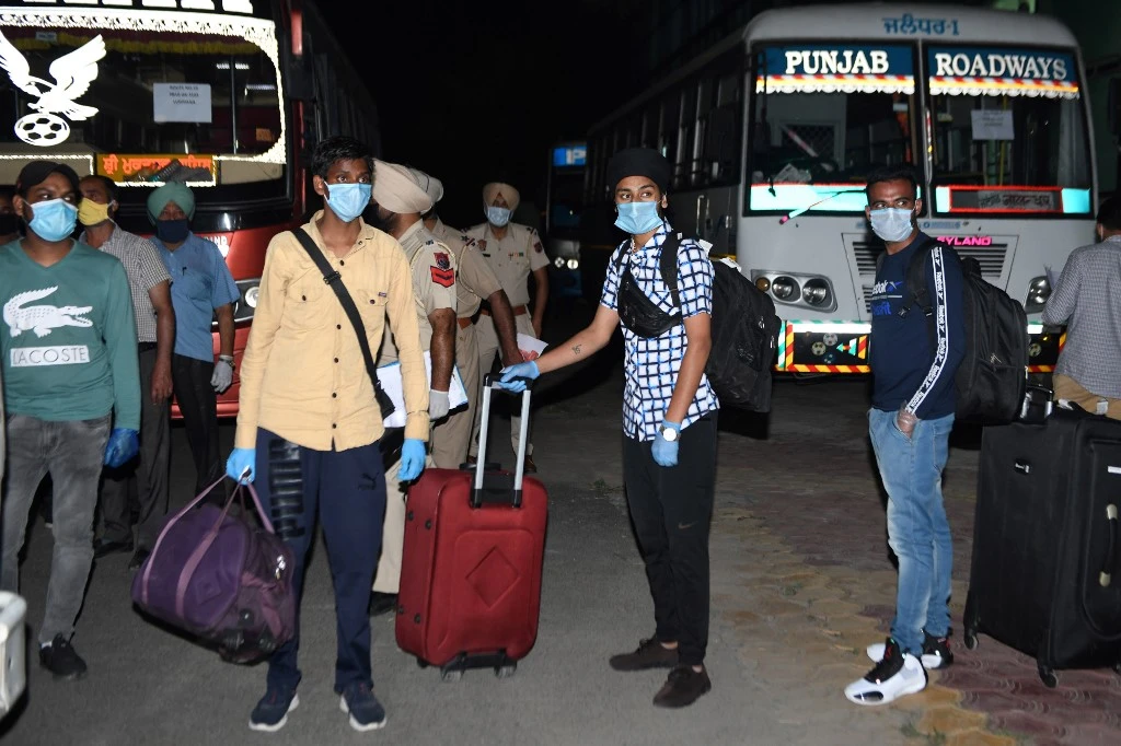Indian nationals returning from Dubai on a special flight wait to be transferred to a quarantine facility on May 13,2020. (AFP)
