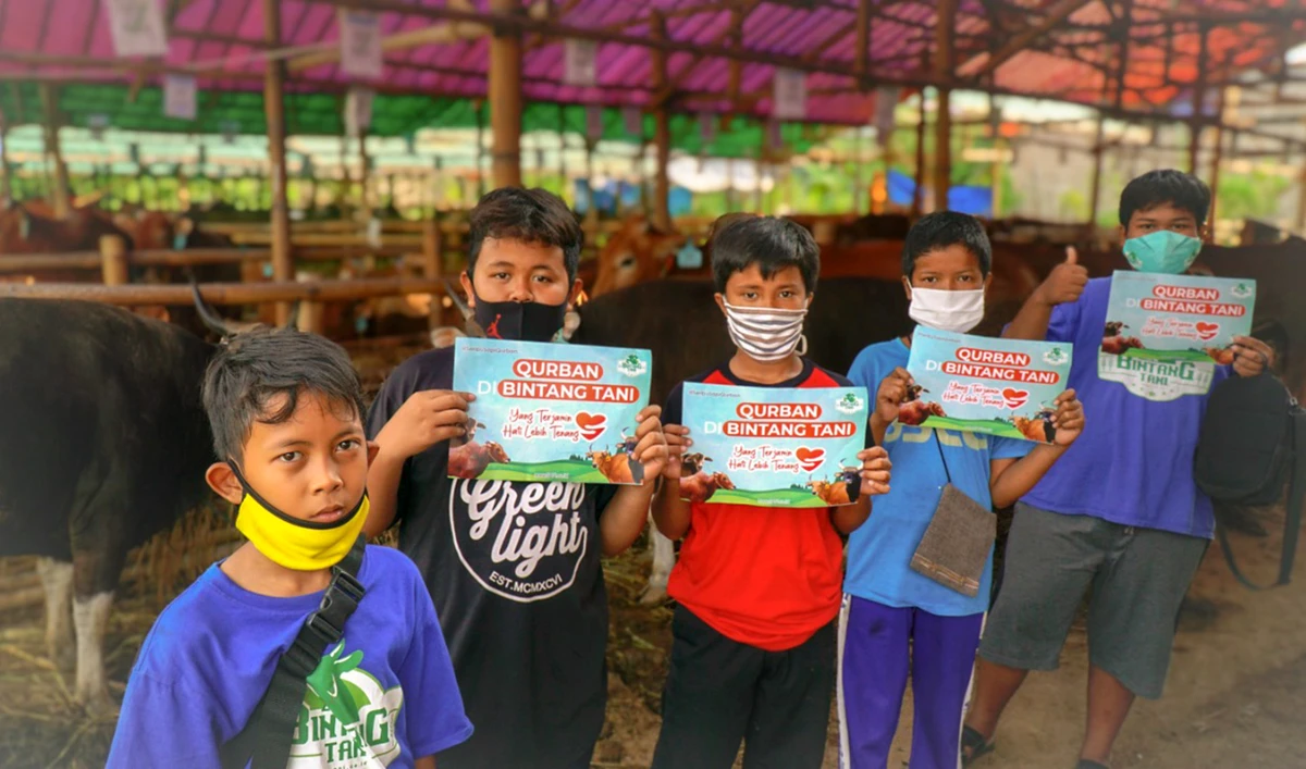 Abu Bakar Sidik (on the far right side of the photo in blue t-shirt) and his friends hold signages as proof of purchase of four cows for this year's Eid Al-Adha festival, with money they had been saving for almost a year. (Photo courtesy: Bintang Sapi Madani)