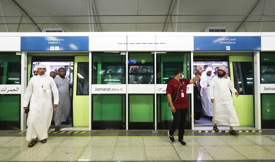 A railway usher gestures to Muslim pilgrims arriving on a Metro from Arafat area to Mina during the annual Hajj season in the western Saudi city of Mecca on August 22, 2018. (AFP)